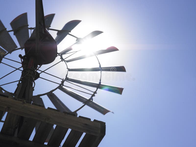 Low angle view of windmill backlit by the sun. Horizontal shot.