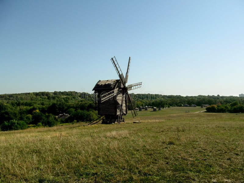 Ukraine, Pyrohiv Kiev - September 17, 2017: An old, rotten, gray wooden mill stands on a hill in the background of a beautiful r royalty free stock images Ukraine, Pyrohiv Kiev - September 17, 2017: An old, rotten, gray wooden mill stands on a hill in the background of a beautiful r royalty free stock images