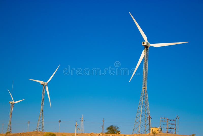 Windmills Standing on a Field with Withered Grass Under the Clear, Blue Sky Stock Photo Image