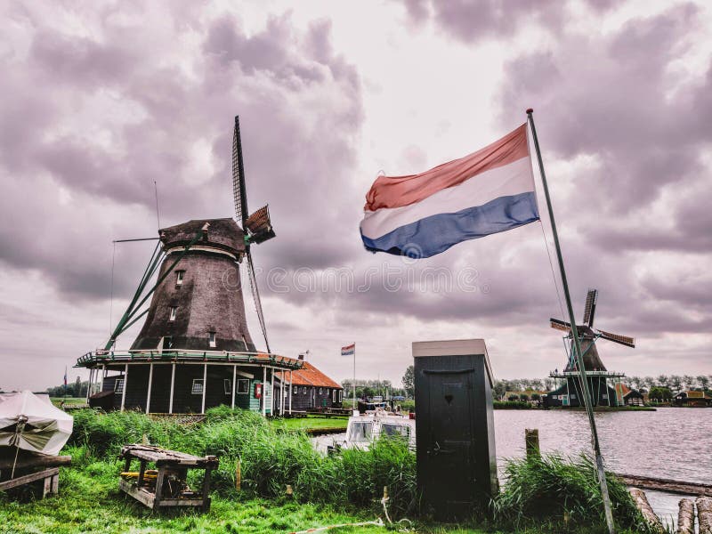 Windmühle mit niederländischer Flagge stockfotos