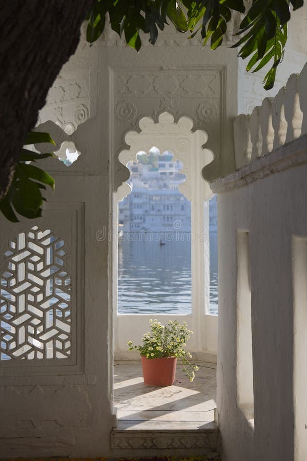 Window. Beautiful View on Pichola Lake. Lake Pichola in Udaipur city in the Indian state Rajasthan. A panoramic view of the water from a luxurious oriental hotel on the beach. Luxury holidays in India