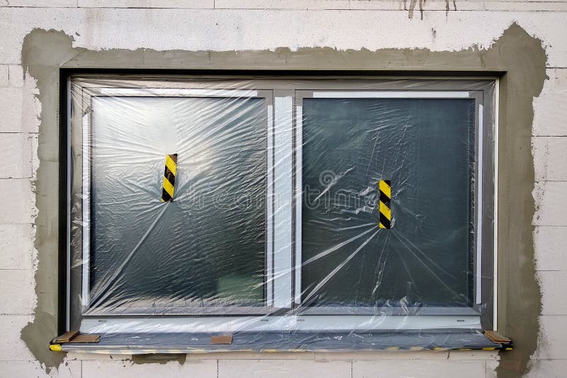 Window of a House Under Construction Covered with Protective Plastic