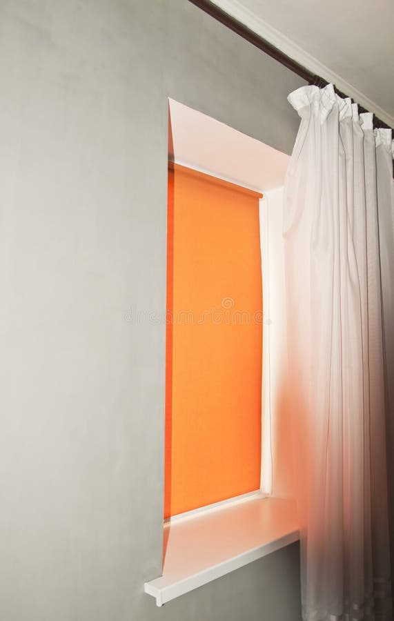 Window with orange rolls and tulle