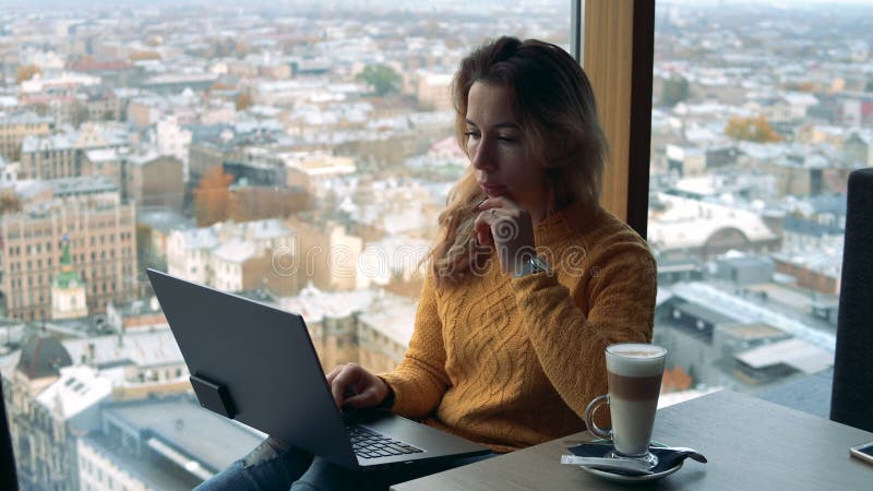 Window-sill with an urban view and a lady working on a computer stock footage