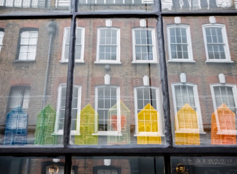 Window of traditional Huguenot weaver`s house on Princelet Street, Spitalfields, showing reflection and quirky model houses