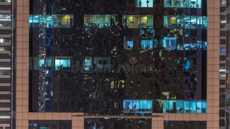 Windows del edificio de varios pisos de la gente interior y móvil de la iluminación de cristal y de acero dentro del timelapse