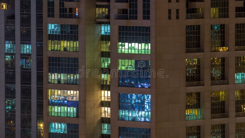 Windows del edificio de varios pisos de la gente interior y móvil de la iluminación de cristal y de acero dentro del timelapse