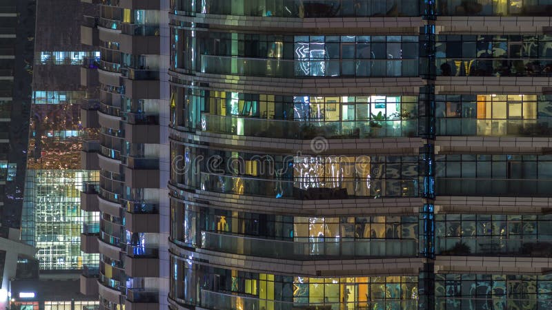 Windows del edificio de varios pisos de la gente interior y móvil de la iluminación de cristal y de acero dentro del timelapse