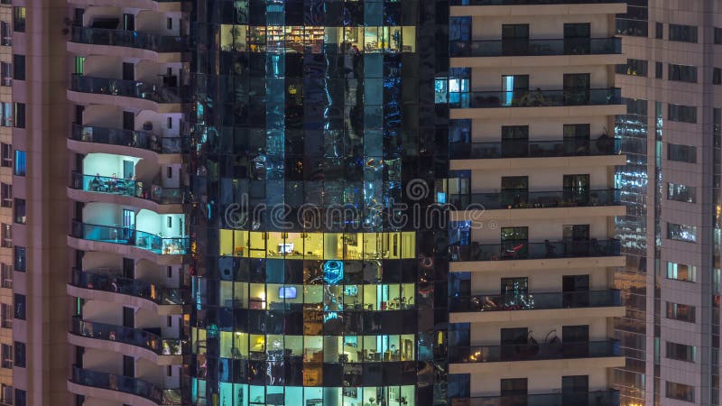 Windows del edificio de varios pisos de la gente interior y móvil de la iluminación de cristal y de acero dentro del timelapse