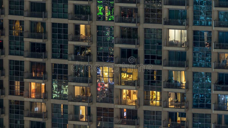 Windows del edificio de varios pisos de la gente interior y móvil de la iluminación de cristal y de acero dentro del timelapse