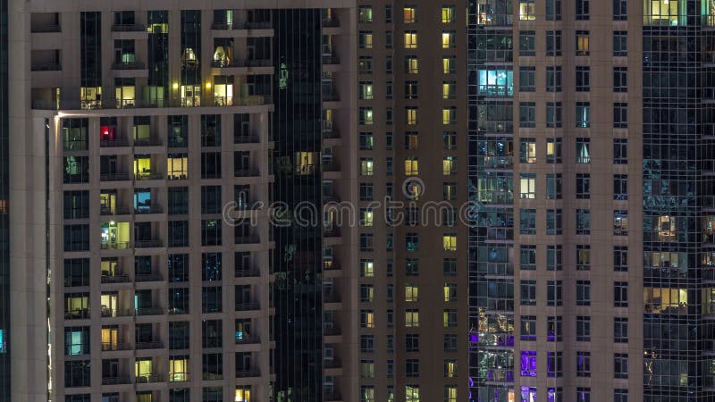 Windows du bâtiment à plusiers étages avec s'allumer à l'intérieur et des personnes en mouvement dans le timelapse d'appartements clips vidéos