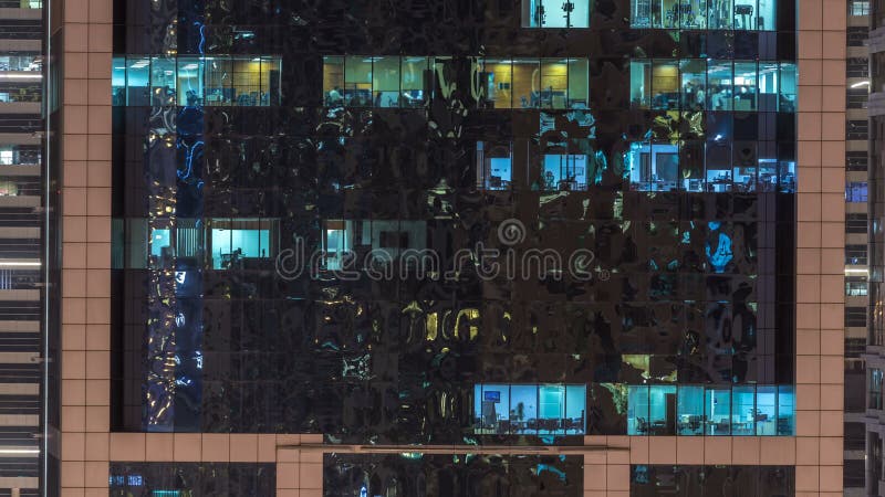 Windows du bâtiment à plusiers étages des personnes intérieures et mobiles d'éclairage en verre et en acier dans le timelapse banque de vidéos