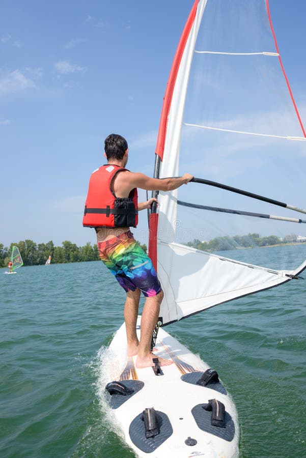 Windsurf del hombre en el lago foto de archivo Windsurf del hombre en el lago foto de archivo