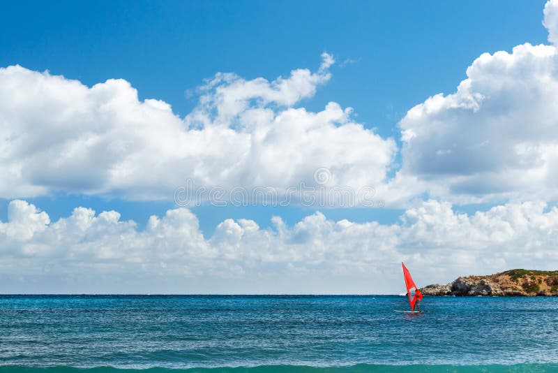 Windsurf with red sail. Water sports on vacations