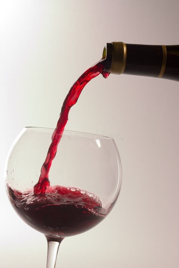 Rosso vino versato da una bottiglia di vetro.