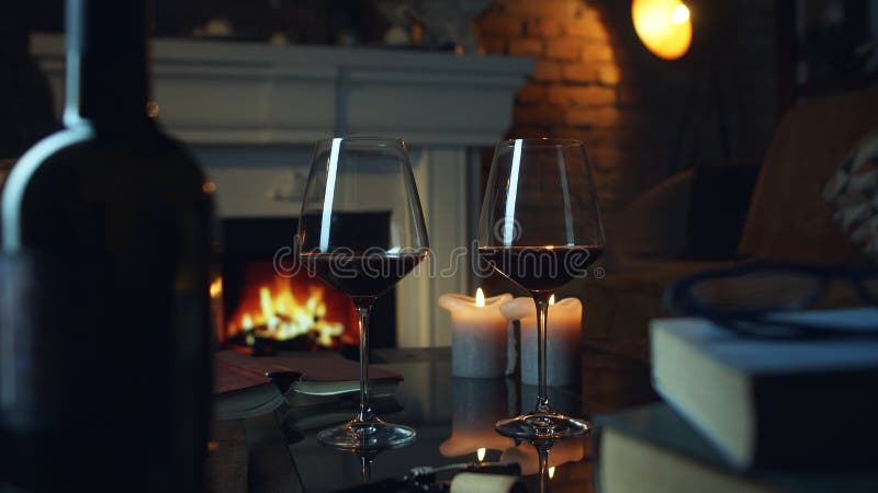 Cup of hot drink and book on blanket near fireplace indoors