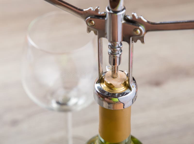 Wine bottle with corkscrew on wooden background