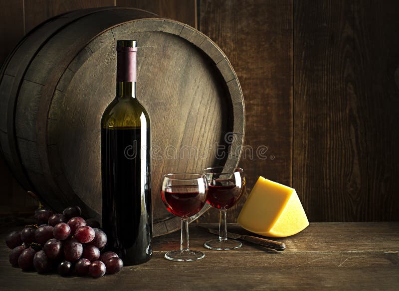 Wine bootle and glasses with cheese on wooden table royalty free stock photo