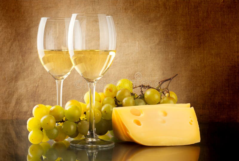 Wine, a bunch of white grapes and a piece of cheese