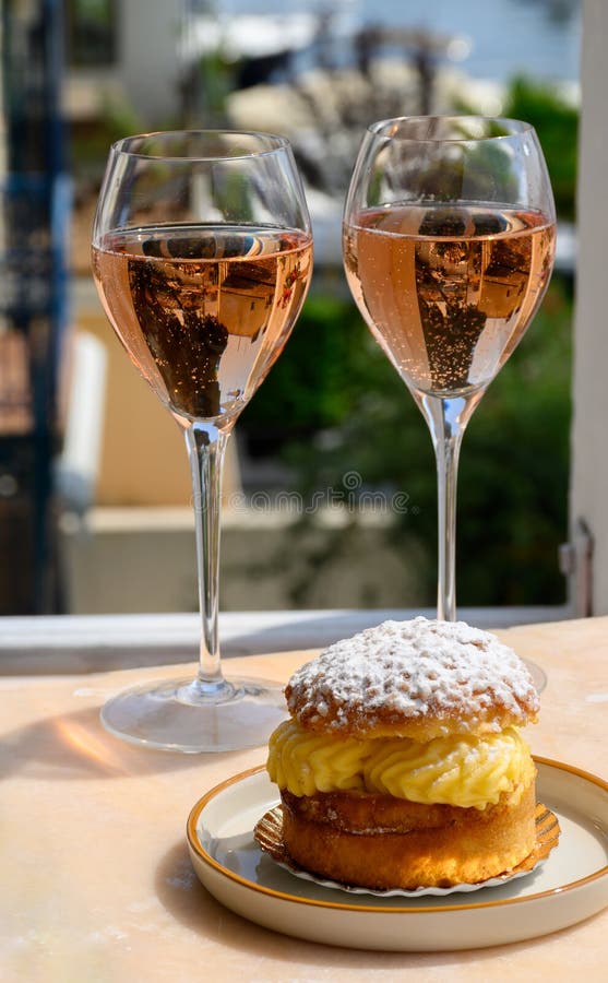 Wine and cake of French Riviera, glasses of cold rose Cote de Provence wine and Tarte Tropezienne cake in yacht harbour of Port royalty free stock photography