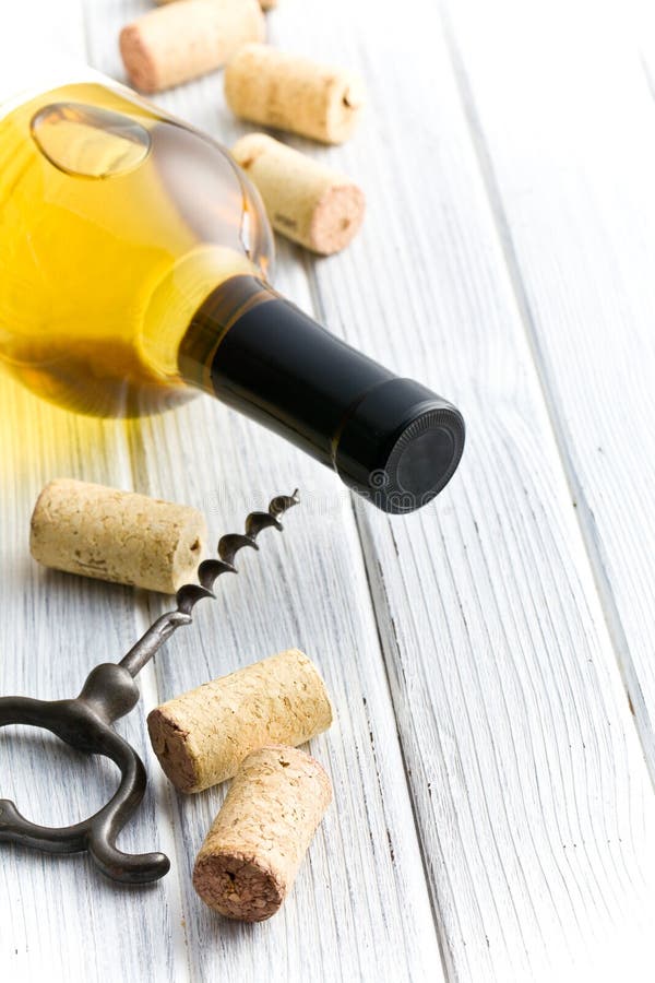 Wine cork, corkscrew and bottle of white wine stock images