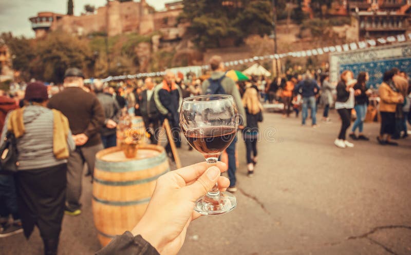 Wine drinkers on the annual city festival Tbilisoba, and crowd of people around. Georgia country.