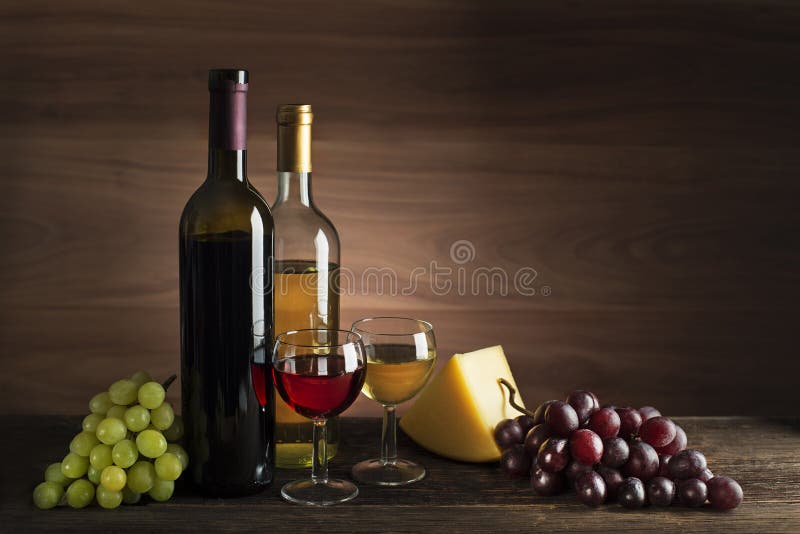 Wine bootle and glass with food on wooden table stock photos