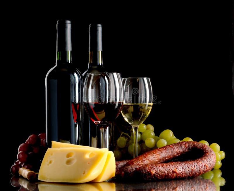 Wine, grapes, cheese and sausage on black background