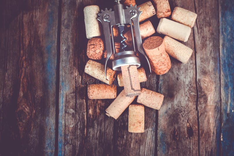 Wine making background with corkscrew and corks from the wine bottles on a wooden table stock photo
