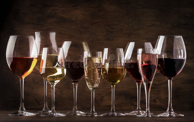 Wine tasting concept, still and sparkling wines. Red, white wine, rose and champagne in wine glasses on vintage wooden table background