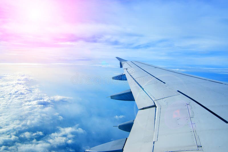 Wing of an airplane flying above the clouds royalty free stock image