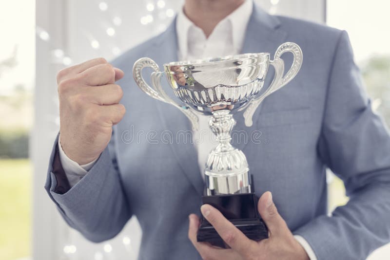 Winning business trophy award for success. Businessman celebrating with trophy award for success in business or first place sporting championship win stock images Winning business trophy award for success. Businessman celebrating with trophy award for success in business or first place sporting championship win stock images