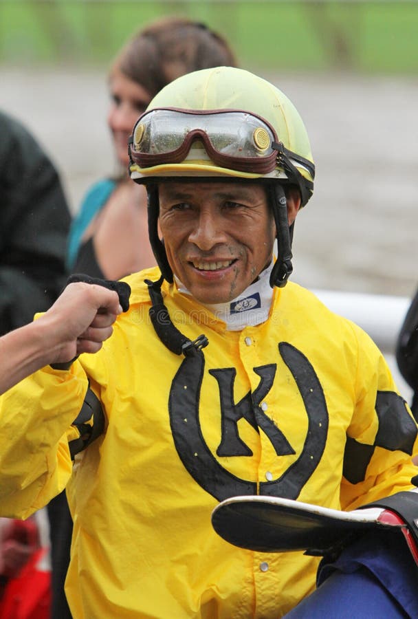 SARATOGA SPRINGS - JUL 23: Jockey Edgar Prado gets a congratulatory fist pump after piloting Silvislip to her first win in a rainstorm at Saratoga Race Course on Jul 23, 2010 in Saratoga Springs, NY. SARATOGA SPRINGS - JUL 23: Jockey Edgar Prado gets a congratulatory fist pump after piloting Silvislip to her first win in a rainstorm at Saratoga Race Course on Jul 23, 2010 in Saratoga Springs, NY.