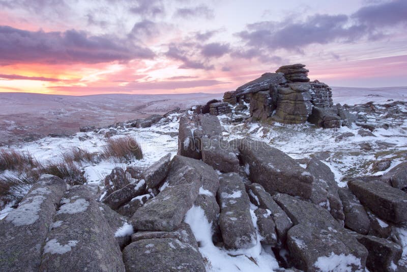 Winter sunrise on a snow covered belstone tor dartmoor devon uk. Winter sunrise on a snow covered belstone tor dartmoor devon uk
