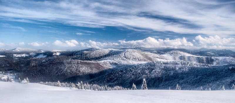 Winter Beskids mountains panorama with snow, hills and blue sky with clouds