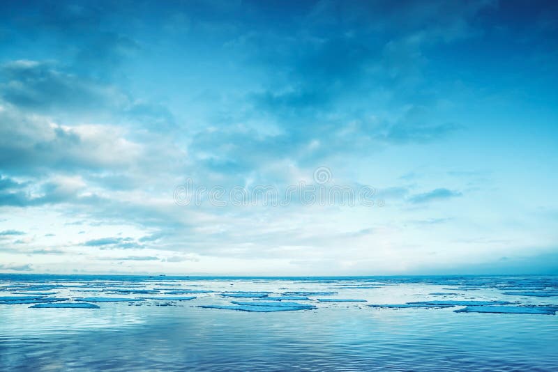 Winter coastal landscape with floating ice fragments and sky