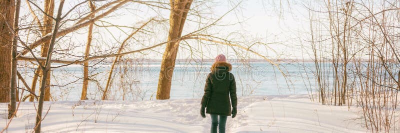 Winter forest walk active woman walking in snow trail outdoor nature panoramic banner. Healthy lifestyle outdoors