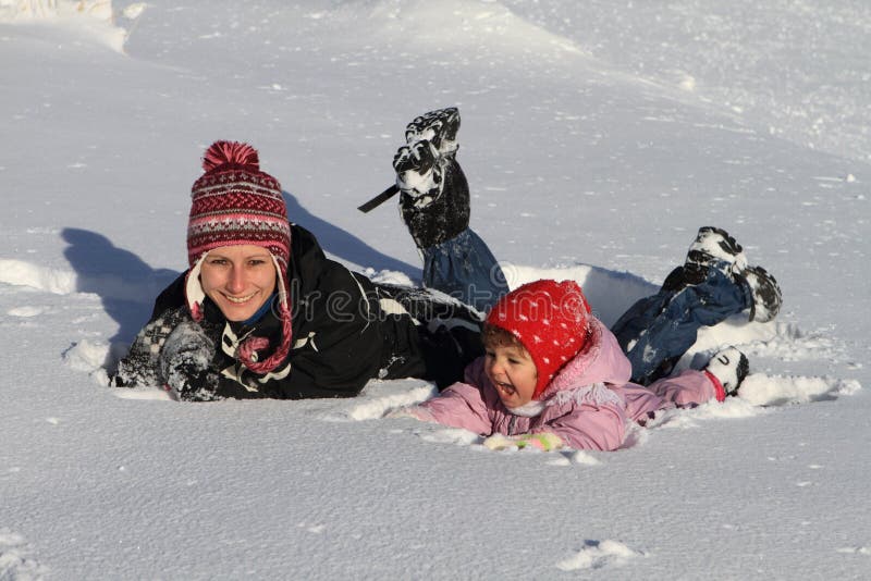 Divertimento invernale madre con bambino che gioca nella neve.