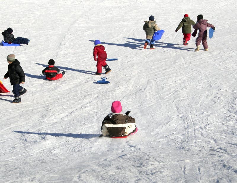 I bambini divertirsi sulla neve slittino.
