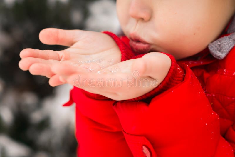 Winter fun. A child blows snow from the palms royalty free stock photos Winter fun. A child blows snow from the palms royalty free stock photos