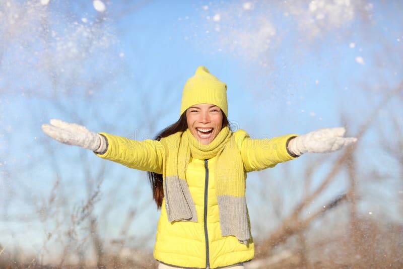 Winter fun girl throwing snow playing outside