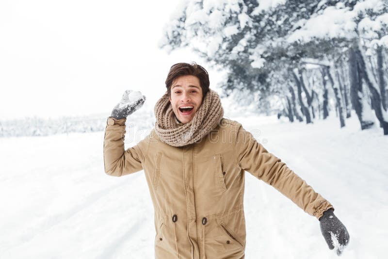 Happy Young Man Throwing Snowball Looking at Camera in Forest Stock ...