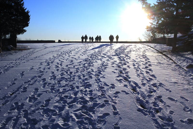 As the sun rose on January 1, a group of people hiked toward the sun leaving their tracks in the white snow. The blue sky gives a cold feeling. As the sun rose on January 1, a group of people hiked toward the sun leaving their tracks in the white snow. The blue sky gives a cold feeling.