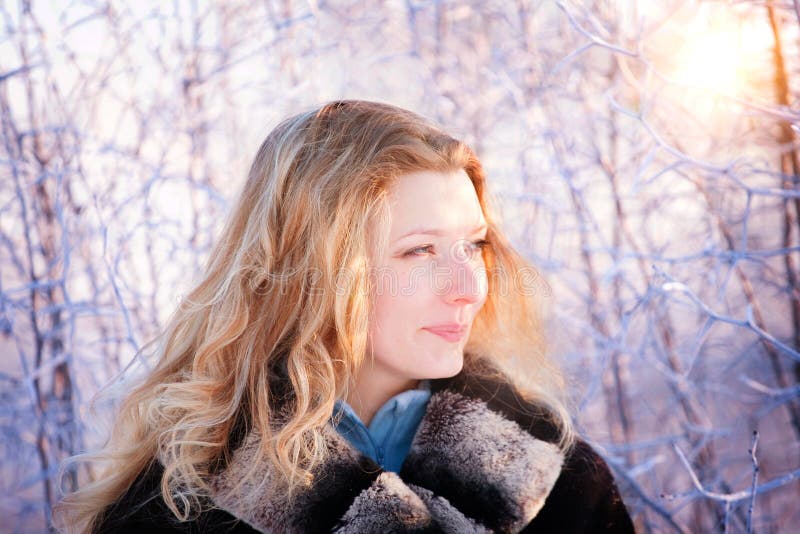 Winter girl behind snow tree