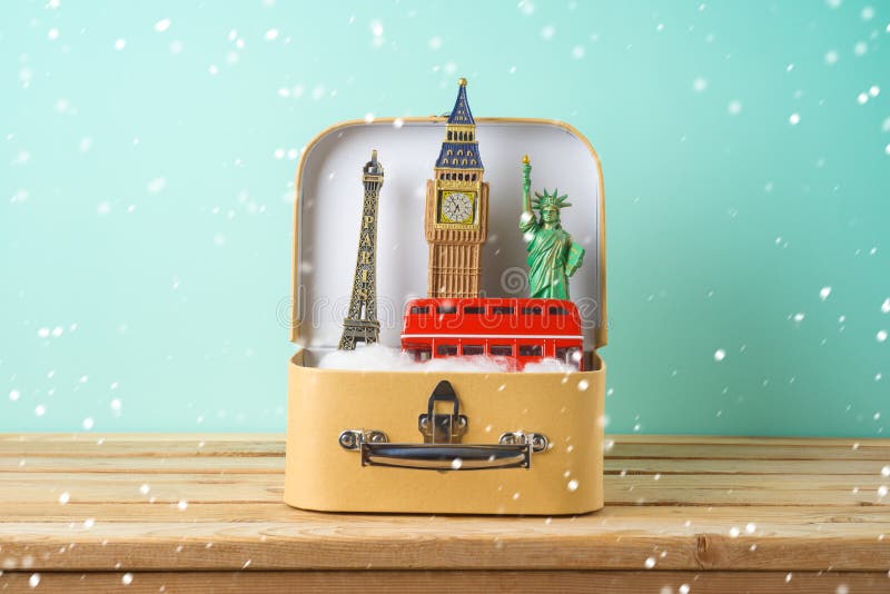 Winter holidays vacation and travel concept with suitcase and souvenirs from around the world on wooden table stock photography Winter holidays vacation and travel concept with suitcase and souvenirs from around the world on wooden table stock photography