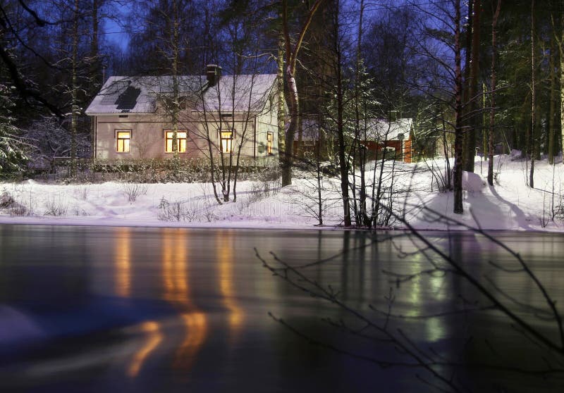 Una casa sulle rive di un fiume ghiacciato.