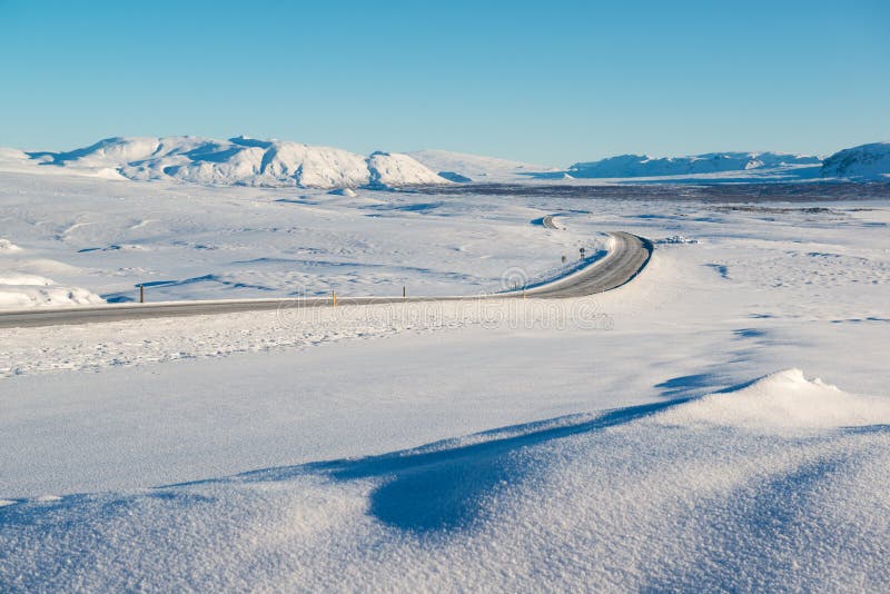 Winter landscape, empty road surrounded by snow capped mountains, Iceland royalty free stock photography Winter landscape, empty road surrounded by snow capped mountains, Iceland royalty free stock photography