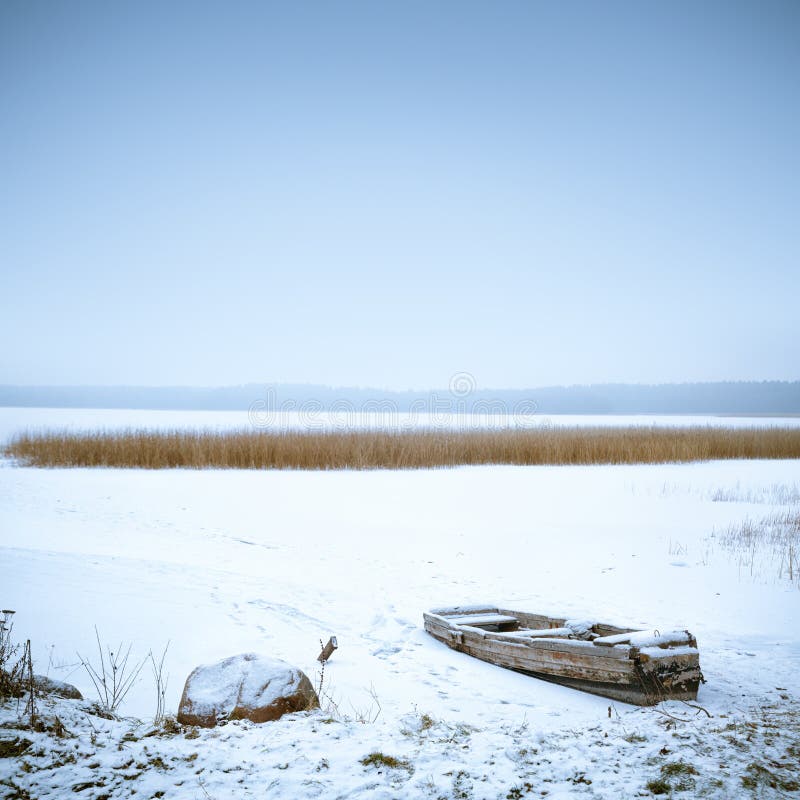 Winter Landscape. Frozen Boat on the Lake.