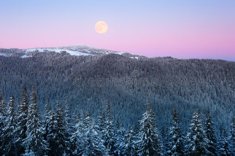 Winter view with a full moon in the mountains