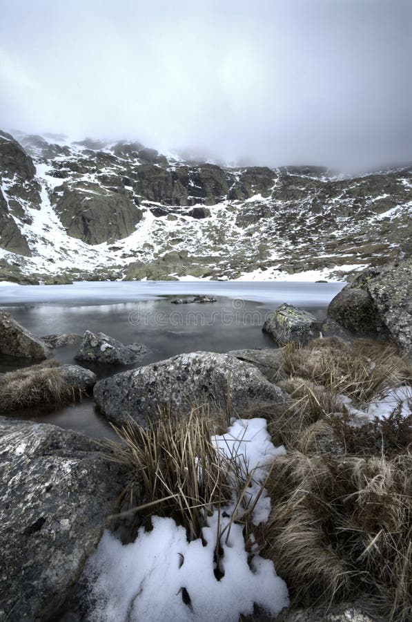 Winter landscape ice lake snow rock storm sky